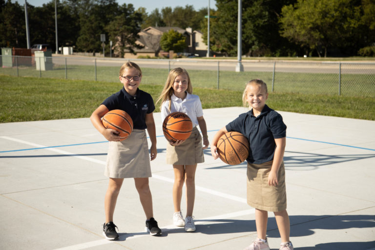 Three children playing basketball